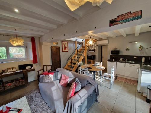 un soggiorno con un divano, un tavolo e una cucina di La Chaine a Saint-Jean-du-Bois