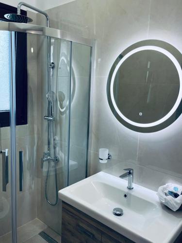 a bathroom with a sink and a shower with a mirror at Onar Apartments in Kalavrita