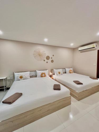 two beds in a room with white walls at Beach home pool villa bangsaray in Bang Sare