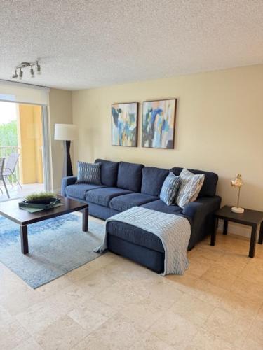 Una sala de estar con un sofá azul y una mesa. en Renovated 2/2 Unit at Yacht Club/Aventura, en Aventura