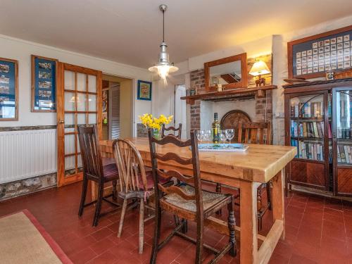 a dining room with a wooden table and chairs at Rogeston Mount - Cottage in Nolton