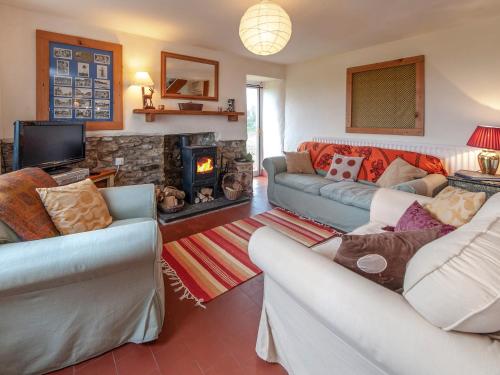 a living room with two couches and a fireplace at Rogeston Mount - Cottage in Nolton
