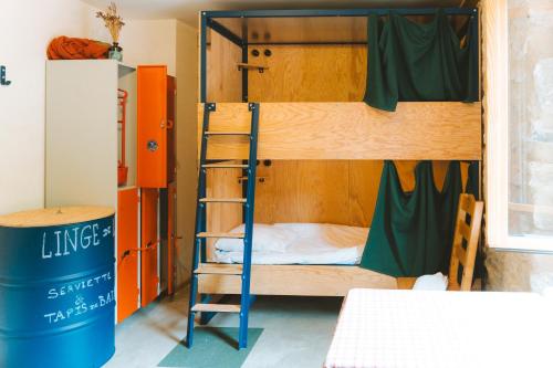 una habitación con literas y un bote de basura en Hostel Quartier Libre, en Saint-Jean-en-Royans