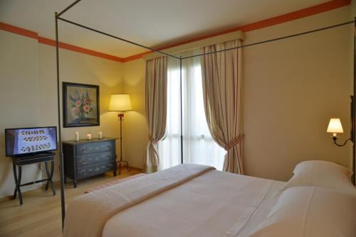 een slaapkamer met een bed, een tv en een raam bij Fonteliving RestArt in San Casciano dei Bagni