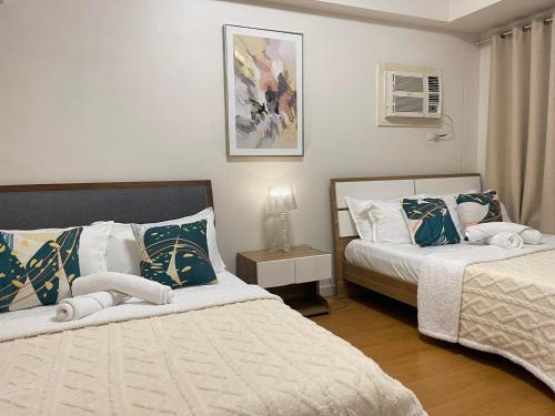 een slaapkamer met twee bedden en een tafel met een lamp bij 8 Adriatico in Manilla