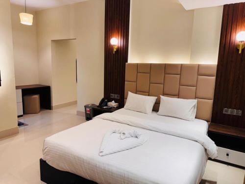 ein Hotelzimmer mit einem Bett mit einem Handtuch darauf in der Unterkunft Grand Khalifa Hotel Hamama in Sylhet