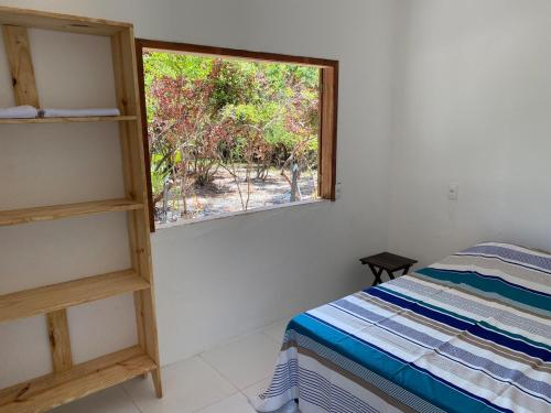 a bedroom with a window and a bed with a ladder at Casa Moreré in Ilha de Boipeba