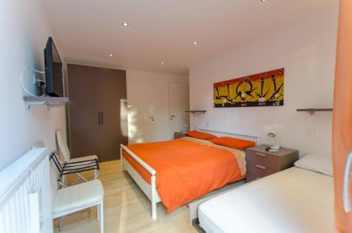 een slaapkamer met een oranje bed en een tv bij 149 Dimora di autore in Borca di Cadore
