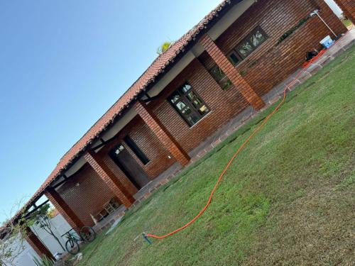 una casa con un aquilone arancione su un campo erboso di Brisa do Oceano - Pousada & Hostel a Caucaia