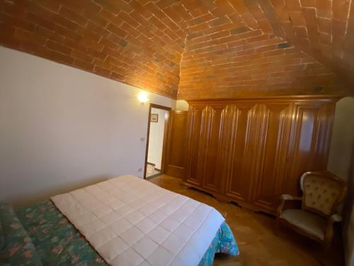 een slaapkamer met een bed en een bakstenen muur bij Lo Sdrucciolo in Laterina