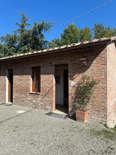 un bâtiment en briques avec une porte et une plante dans l'établissement L'Albero di Gamelì Apartments, à Chiusi