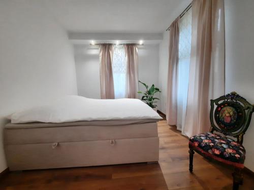 a bedroom with a bed and a chair at Cozy Zdrój in Lądek-Zdrój