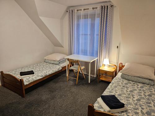 una camera da letto con due letti, una scrivania e una finestra di Pokoje w ,,Stajni ,, a Niemce