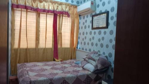 a bedroom with a bed and a window at el-yusra homestay in Bayan Lepas