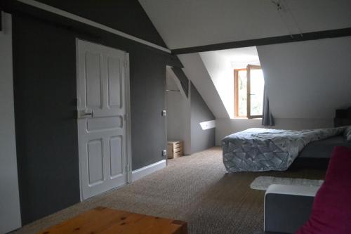 ein Schlafzimmer mit einem Bett und einer Tür mit einem Fenster in der Unterkunft Chambre spacieuse proche du centre ville in Villefranche-de-Rouergue