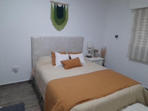 a bedroom with a large bed with orange pillows at Oasis urbano! Apartamento Geminis complejo in San Nicolás de los Arroyos