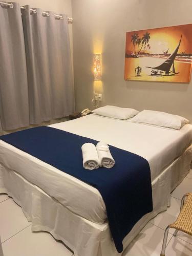 a bedroom with a large bed with towels on it at Hotel Encontro do Sol in Fortaleza
