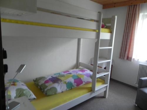 1 dormitorio con litera y escalera en Ferienwohnung Schautzgy en Reutte