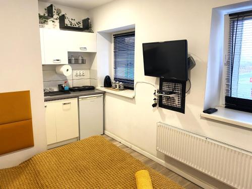 een kleine keuken met een tv aan de muur bij Lemuria Studio Łokietka in Legnica