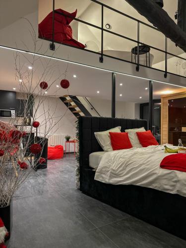 a bedroom with a large bed with red pillows at LCforyou in Juprelle