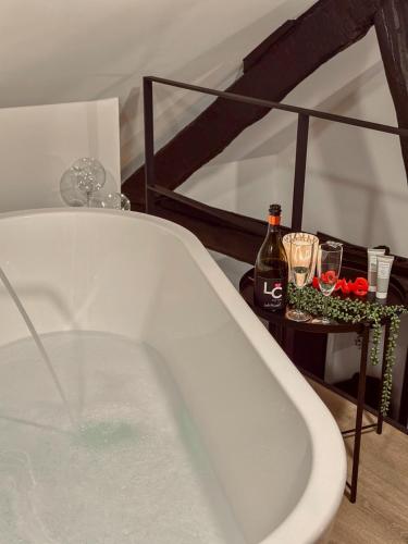 a bath tub with a bottle of wine and glasses at LCforyou in Juprelle