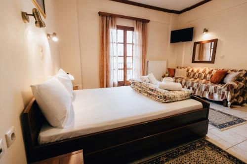 ein Schlafzimmer mit einem großen Bett und einer Couch in der Unterkunft Studios EYTYXIA-3 in Kalavryta