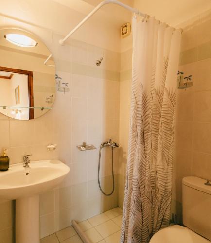 a bathroom with a shower curtain and a sink at Studios EYTYXIA-3 in Kalavrita