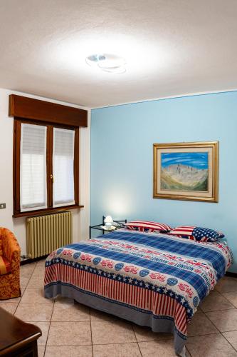 a bedroom with a bed with a blue wall at Appartamento Clivo in Solto Collina
