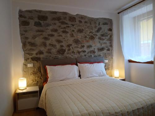 een slaapkamer met een groot bed met twee lampen bij Comelico CasaVacanza in Santo Stefano di Cadore