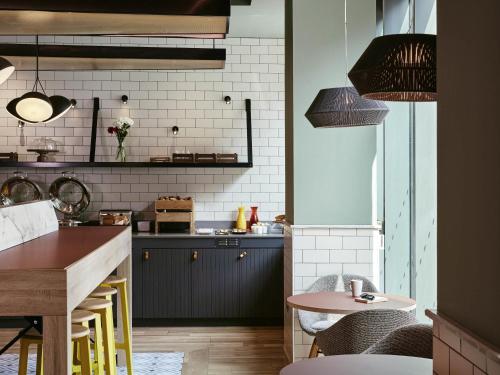 una cocina con armarios azules y una mesa. en Aparthotel Adagio Glasgow Central, en Glasgow