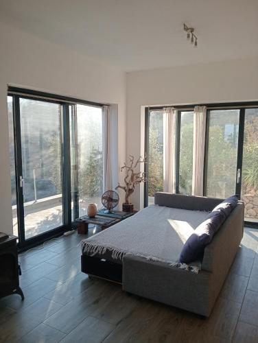 a bedroom with a large bed and large windows at Sea Breeze Ecological Villa in Agia Galini