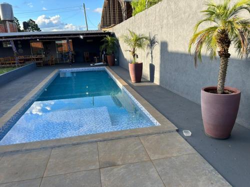 einen Pool mit einer Palme neben einem Gebäude in der Unterkunft Cabañas Luna 