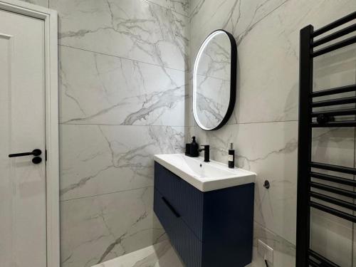 een badkamer met een wastafel en een spiegel bij Louisville Flat 3 in Newmarket