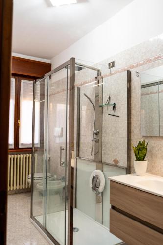 a bathroom with a glass shower and a sink at Appartamento Clivo in Solto Collina