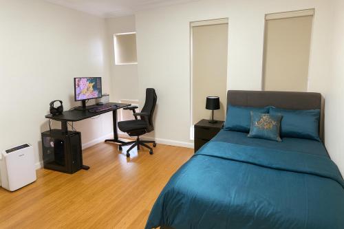 a bedroom with a bed and a desk with a computer at Fascinating Neon - Master Room Beside Station - With Private bathroom and walk-in wardrobe in Sydney