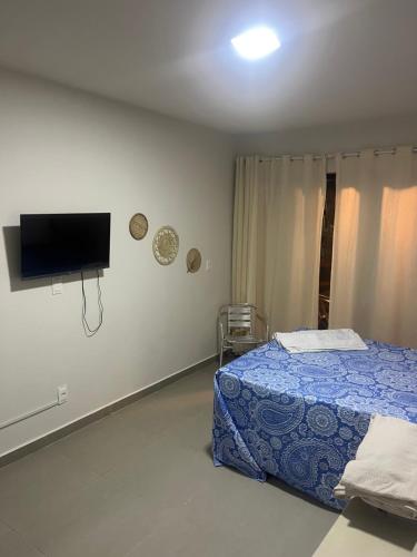 una camera da letto con un letto e una TV a schermo piatto di Flat mar a Coruripe