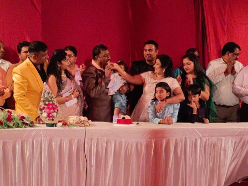 eine Gruppe von Menschen steht um einen Tisch herum in der Unterkunft Chavan White House Farm and Stay in Badlapur