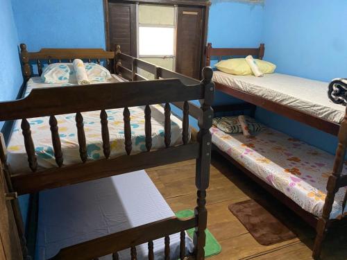 two bunk beds in a room with a window at De la rosa y el canto de los pájaros in Paraty