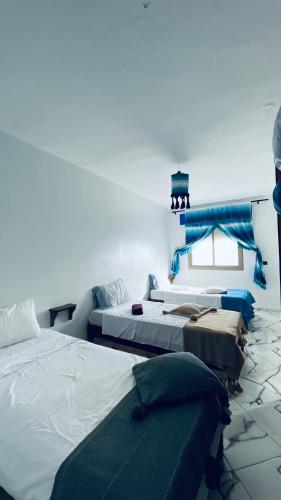 a room with three beds and a window at dar naim in Chefchaouen