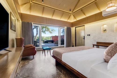 um quarto de hotel com uma cama e uma janela grande em Wild Forest Sasan Gir Wildlife sanctuary em Sasan Gir