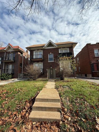 a brick house with a sidewalk in front of it at Delmar Loop 2-Bedroom Retreat in University City