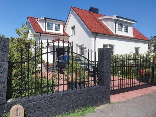 a black fence in front of a white house at Sunset Stay in Malmö