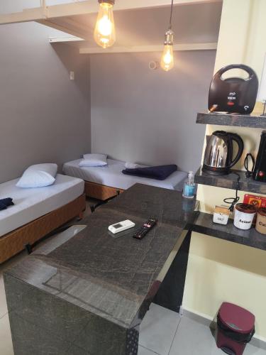 a small room with two beds and a table at Pousada Confort in São Paulo