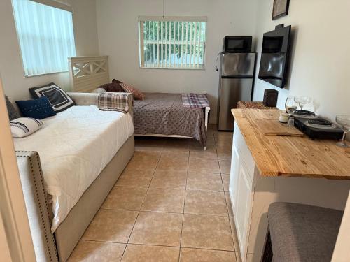 a room with a bed and a table and a refrigerator at El Shaddai Faithfully Beach in Hollywood