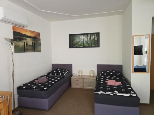 een slaapkamer met 2 bedden en een tafel en een lamp bij Ferien- und Gästewohnung mit AC in Osterburg Siedlung