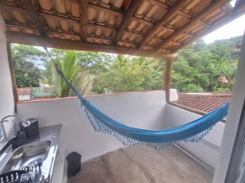 een hangmat op het balkon van een huis bij Alma Surf House in Boicucanga