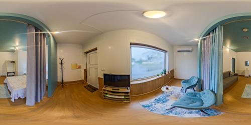 a living room with a large window and a tv at Cantinho dos Remédios in Lajes