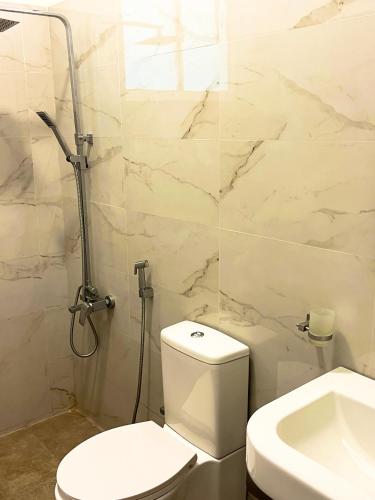 a white bathroom with a toilet and a sink at Golden Residence in Anuradhapura
