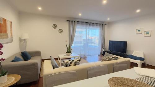 a living room with a couch and a tv at BARRAMARES 3 in Furadouro