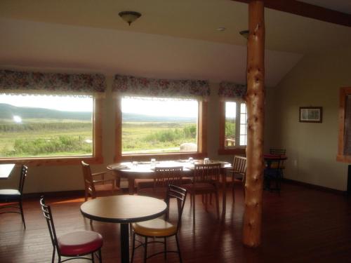 a dining room with tables and chairs and a large window at Wildberry North in St. Anthony